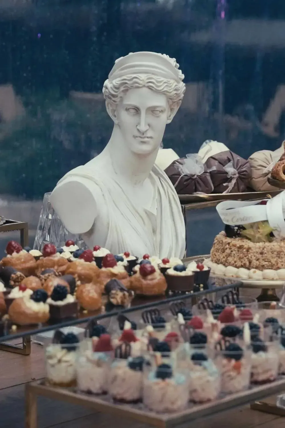 Tavolo dei dolci con un busto classico, dettaglio di un ricevimento