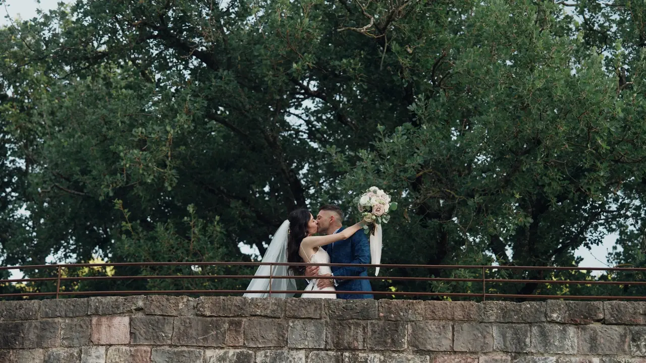 Bacio degli sposi su un ponte di pietra
